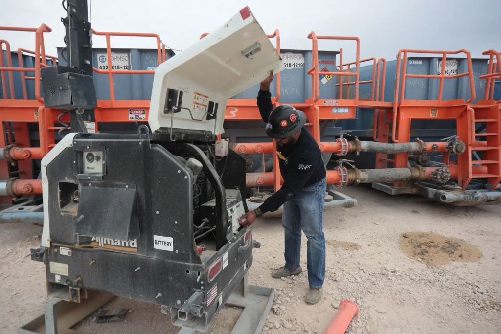 Worker inspecting industrial generator equipment.