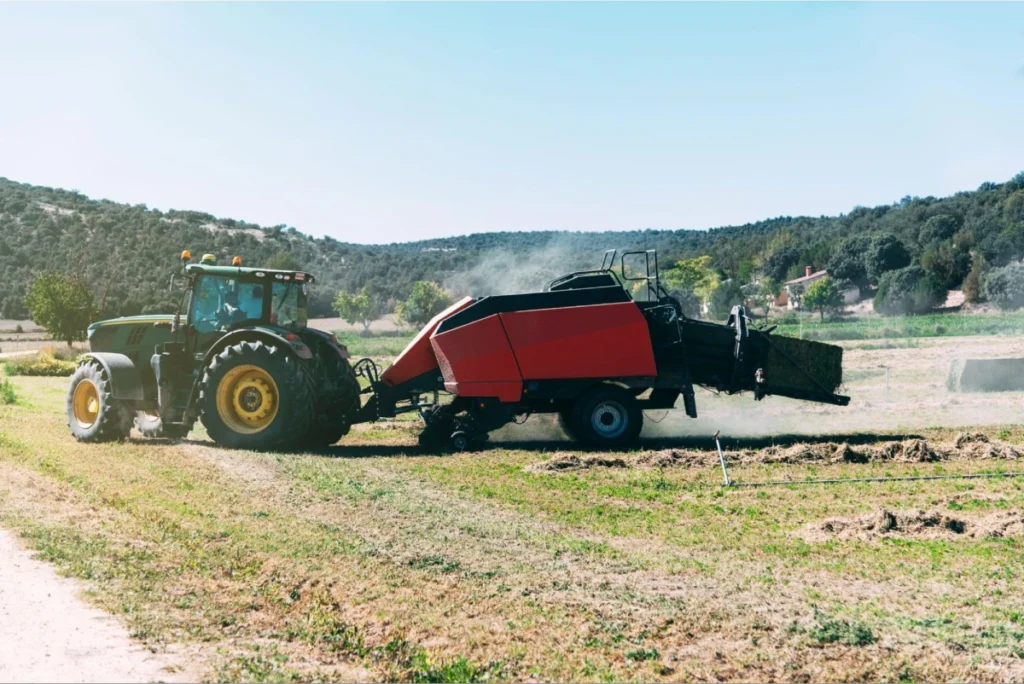Tractor with hay baler in field